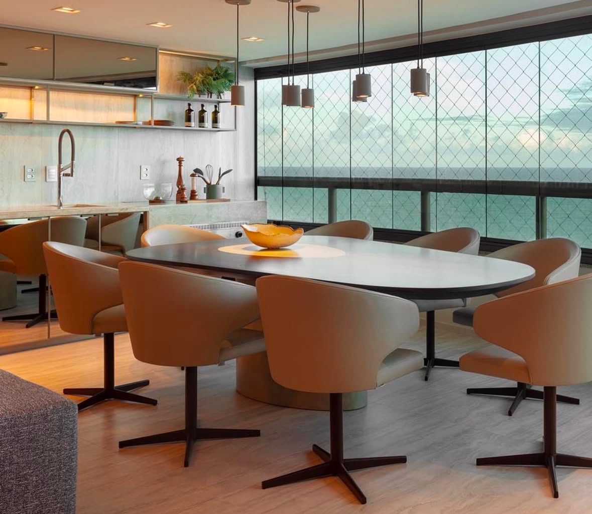 Sala de jantar com cadeiras giratórias e vista para o mar