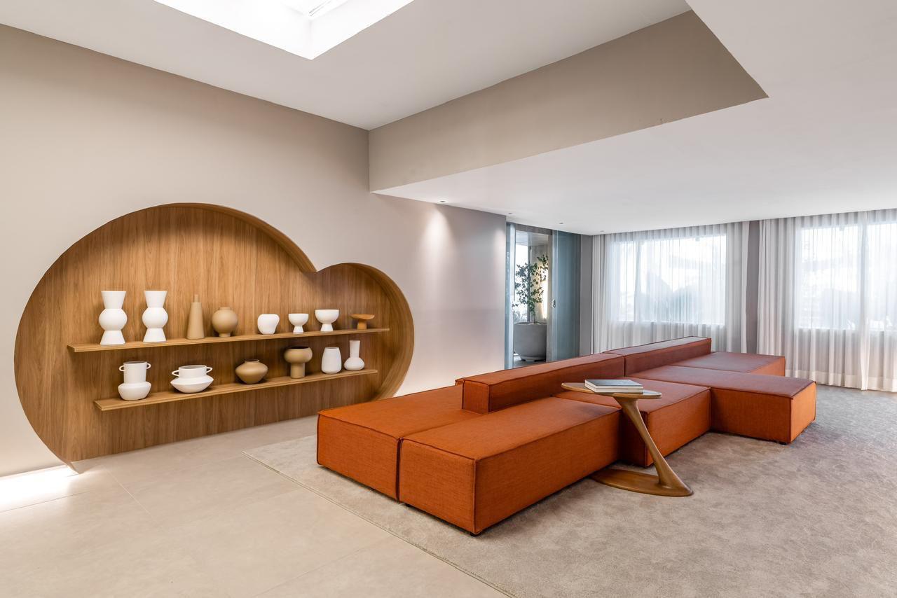 Sala de estar com sofá modular terracota e nicho em madeira